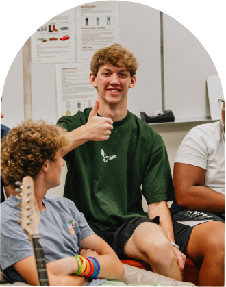boy in a green shirt doing a thumbs up