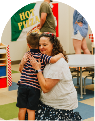 teacher hugging a little boy