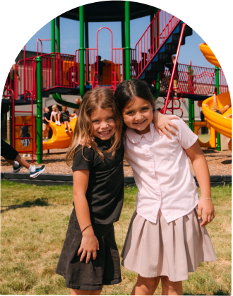 two little girls hugging on the playground
