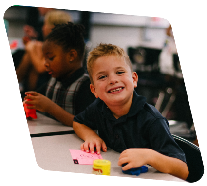 little kid at his desk during the school day